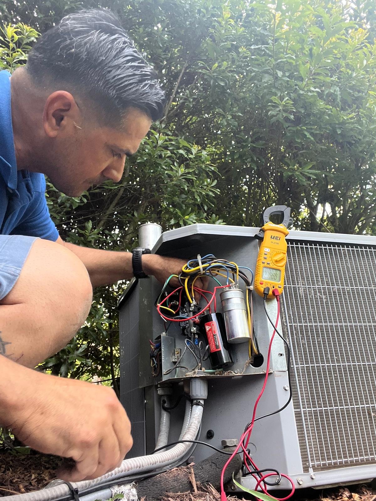 Technician tuning an outdoor condenser unit